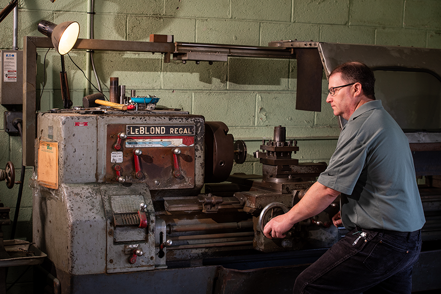 Employee using lathe to trim pump impeller